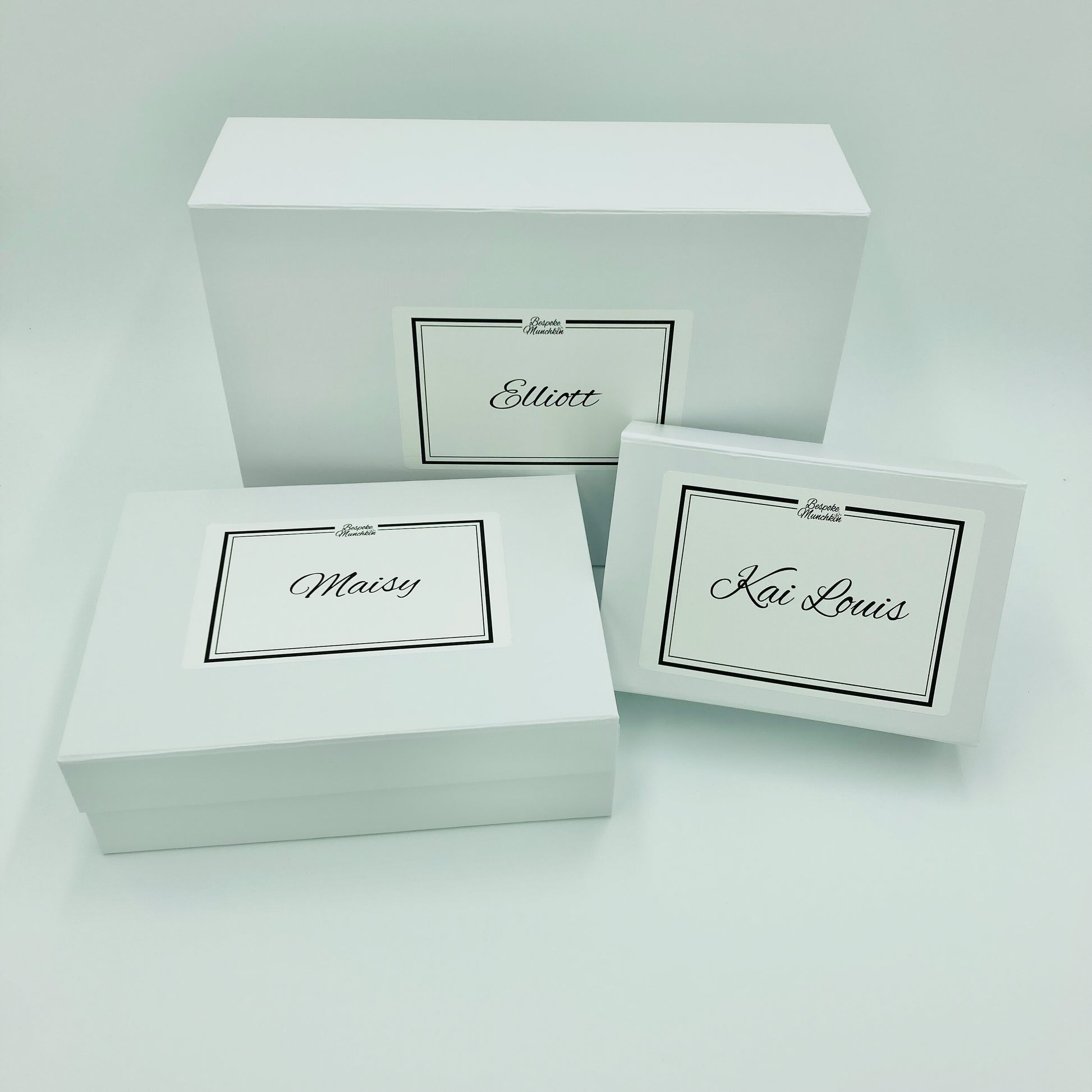 Three different sized personalised white magnetic boxes against a white background. Your order will be packaged in a free personalised magnetic box.