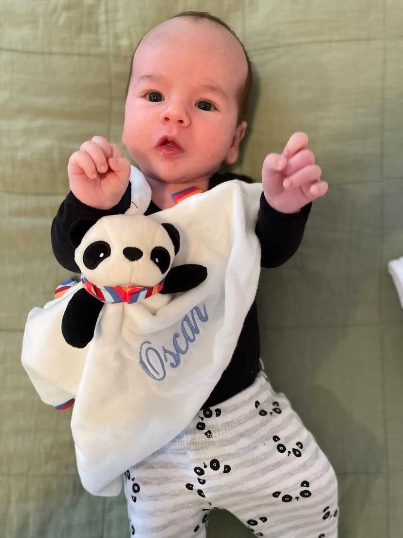 Panda Baby comforter, personalised with baby's name in light blue thead. Photo also has a picture of a cute baby playing with his baby comforter. 